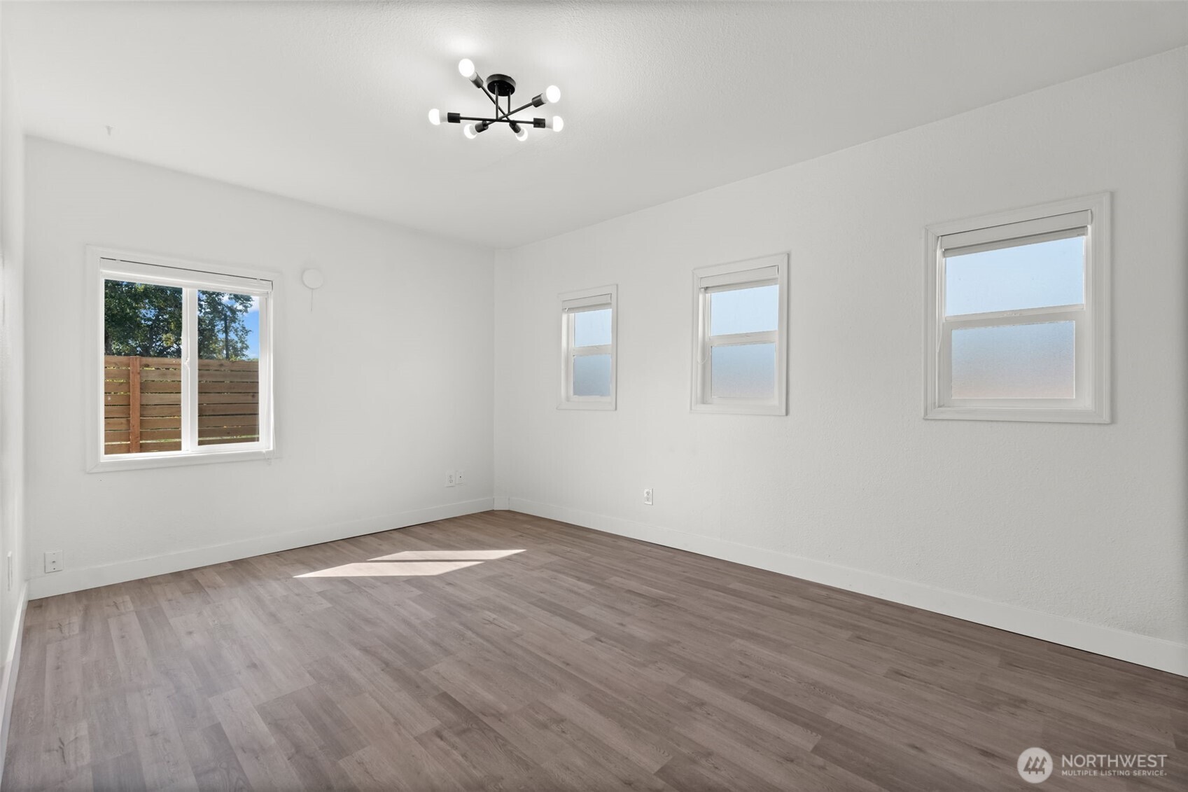14915 Portland Avenue Southwest Lakewood, WA 98498 - Photo 9 of 29 a view of an empty room with a window and wooden floor