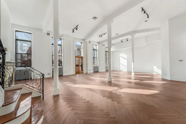 a view of a livingroom with wooden floor and furniture