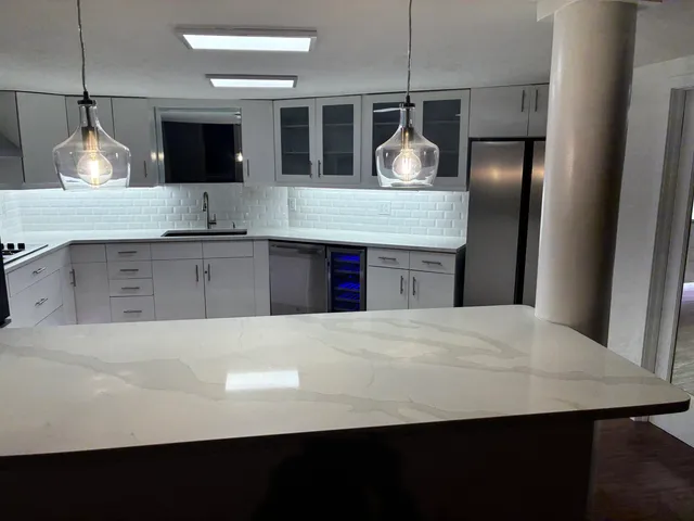 a kitchen with kitchen island a counter top space cabinets and stainless steel appliances