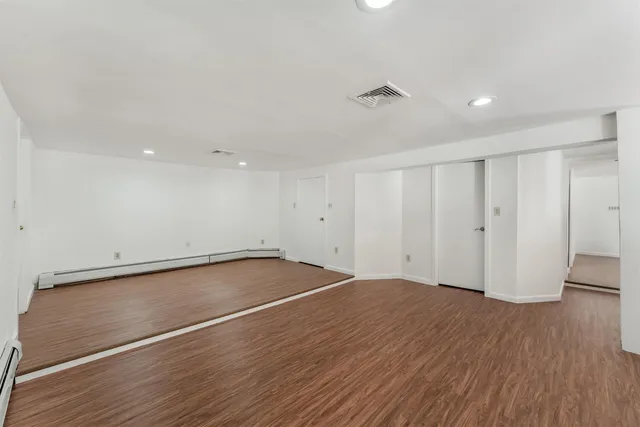 a view of an empty room with wooden floor