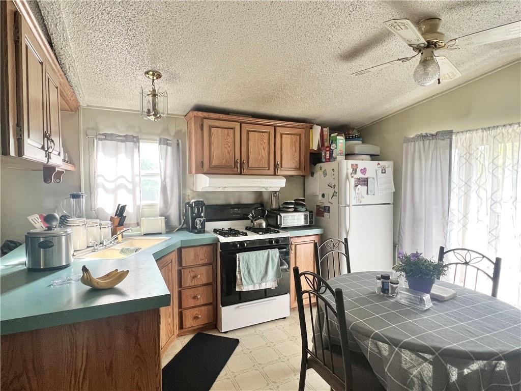 518 Gardner Road New Castle, PA 16101 - Photo 5 of 10 a kitchen with stainless steel appliances granite countertop a stove a refrigerator a sink a dining table and chairs with wooden floor