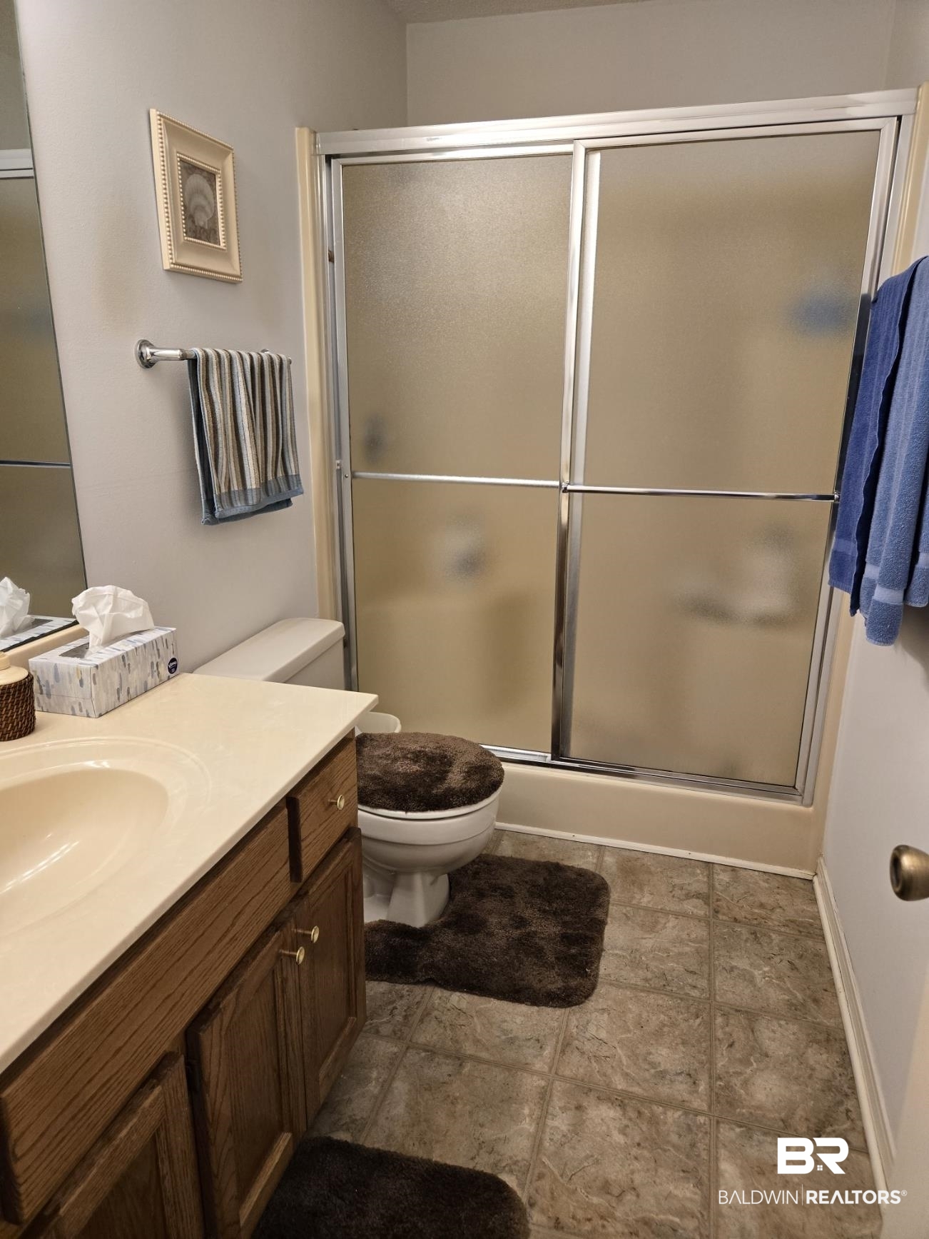 3200 Loop Road, Unit 87 Orange Beach, AL 36561 - Photo 34 of 46 Bathroom with tile patterned flooring, toilet, vanity, and an enclosed shower