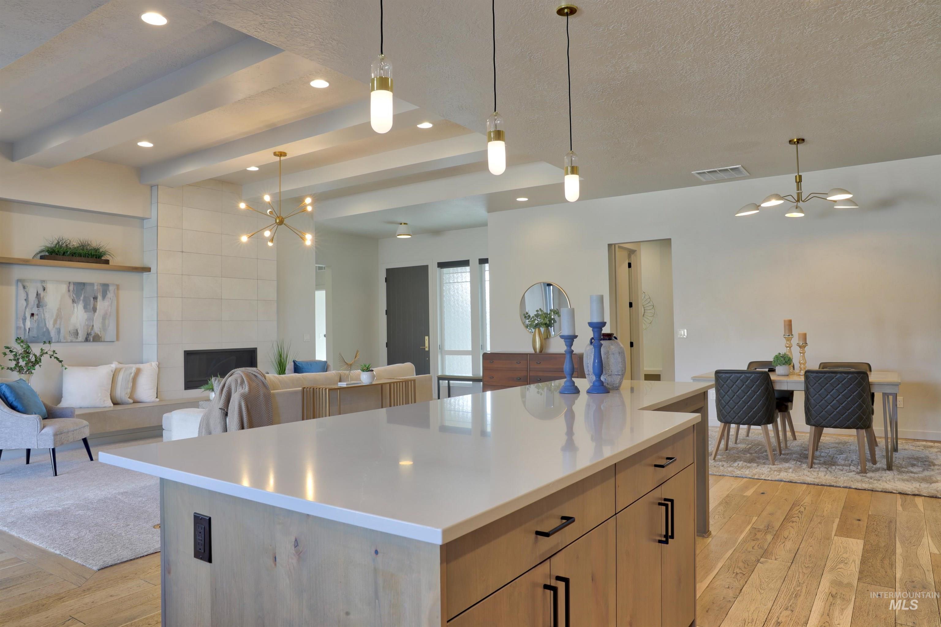 4148 East Copper Point Drive Meridian, ID 83642 - Photo 26 of 26 Kitchen with a chandelier, open floor plan, light wood-style flooring, a tray ceiling, and a textured ceiling