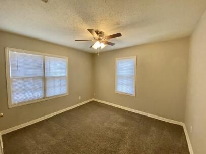 2805 37th Street Lubbock, TX 79413 - Photo 8 of 11 an empty room with a window and a ceiling fan