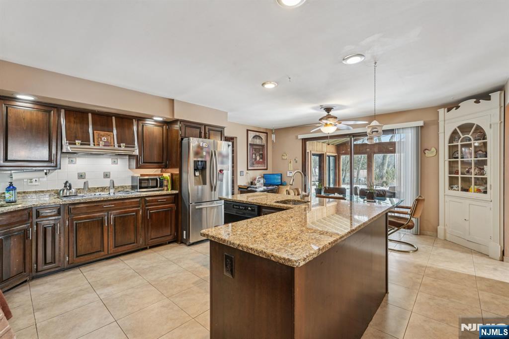 845 Rifle Camp Road Woodland Park, NJ 07424 - Photo 11 of 50 a large kitchen with granite countertop a large counter top appliances and cabinets