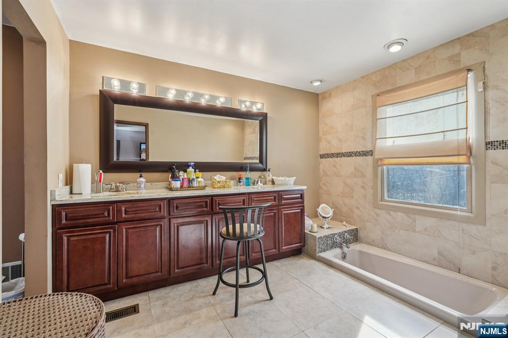 845 Rifle Camp Road Woodland Park, NJ 07424 - Photo 32 of 50 a bathroom with a granite countertop sink and a mirror