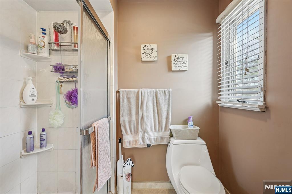 845 Rifle Camp Road Woodland Park, NJ 07424 - Photo 33 of 50 a bathroom with a toilet and a shower curtain