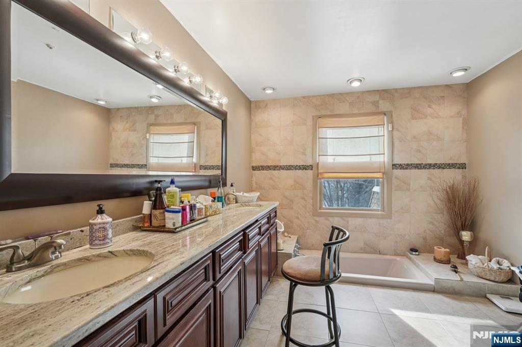 845 Rifle Camp Road Woodland Park, NJ 07424 - Photo 34 of 50 a bathroom with a granite countertop sink mirror and a bathtub