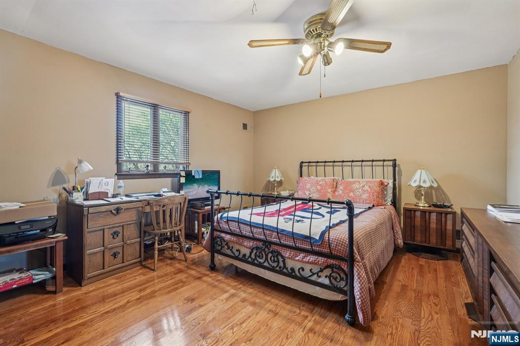845 Rifle Camp Road Woodland Park, NJ 07424 - Photo 35 of 50 a bedroom with a bed and a chandelier