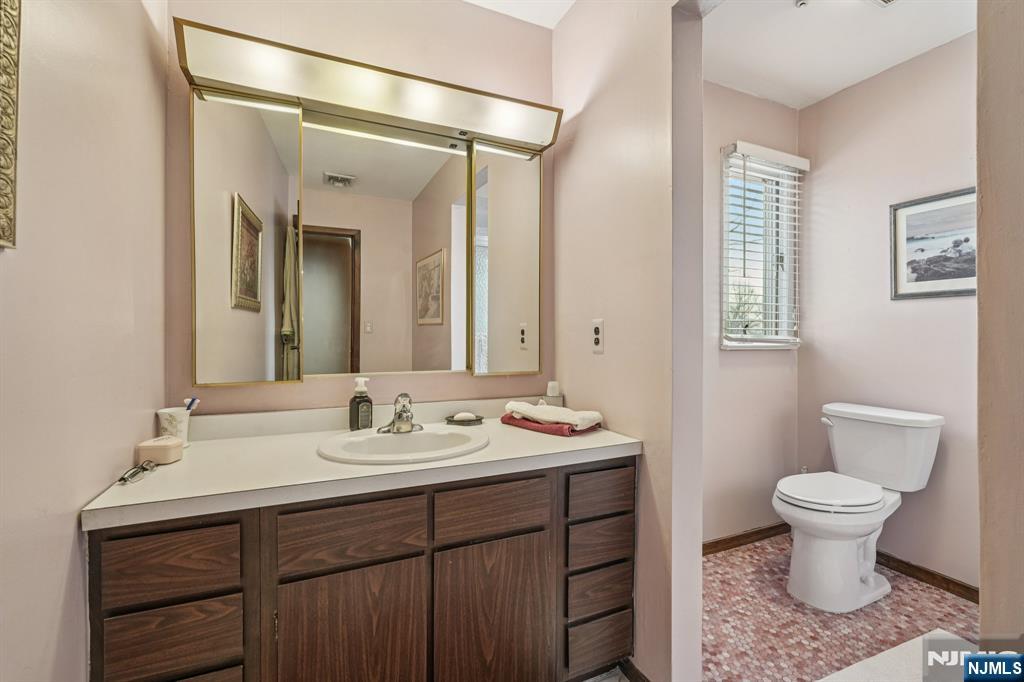 845 Rifle Camp Road Woodland Park, NJ 07424 - Photo 39 of 50 a bathroom with a sink toilet a mirror and shower