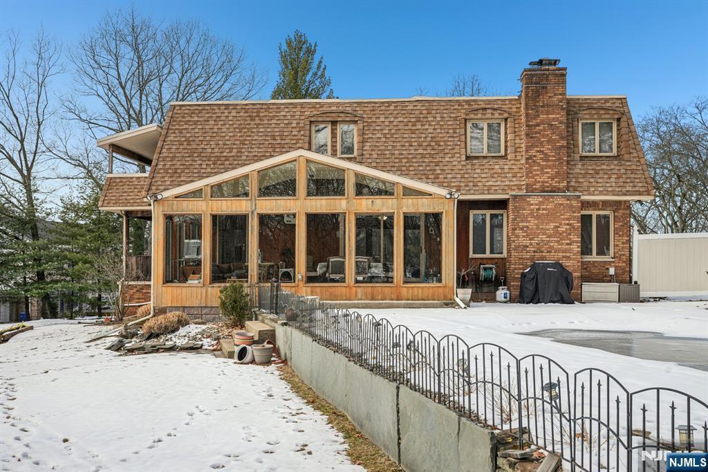 845 Rifle Camp Road Woodland Park, NJ 07424 - Photo 41 of 50 a view of a brick house with large windows and a table