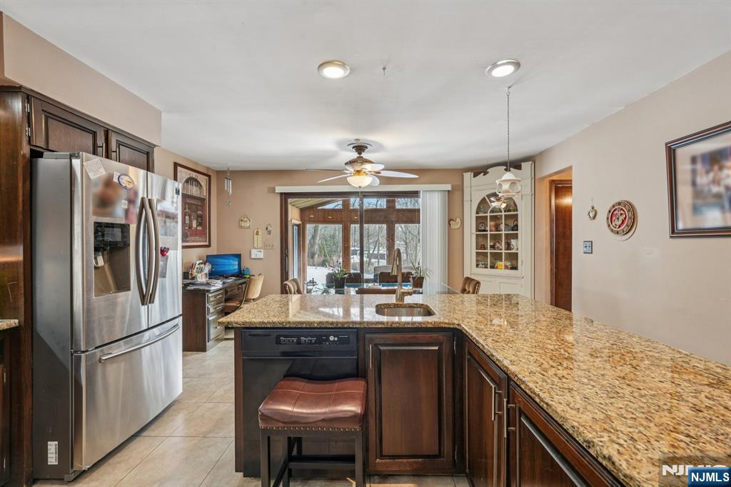 845 Rifle Camp Road Woodland Park, NJ 07424 - Photo 8 of 50 a kitchen with stainless steel appliances granite countertop a sink stove and refrigerator