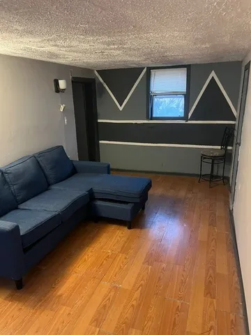 a living room with a couch and wooden floor