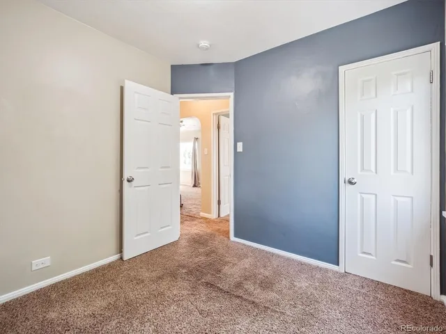 an empty room with closet and a bathroom