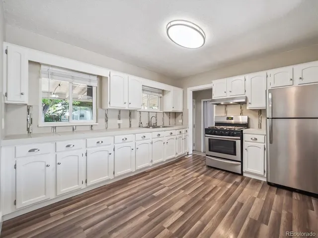 a kitchen with granite countertop white cabinets and white appliances