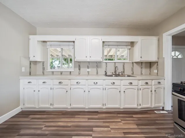 a kitchen with granite countertop white cabinets and white appliances