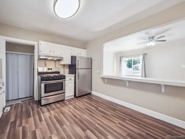 a kitchen with a refrigerator and a stove top oven