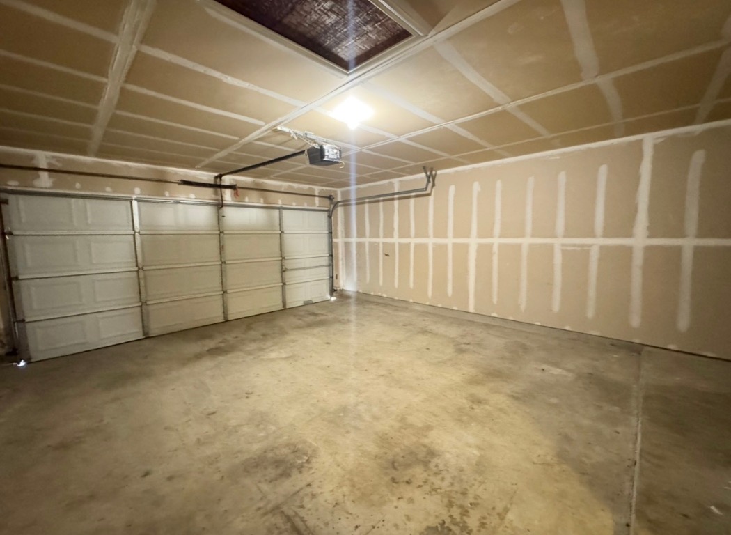 12809 Wood Lily Trail Elgin, TX 78621 - Photo 23 of 26 Garage featuring a garage door opener