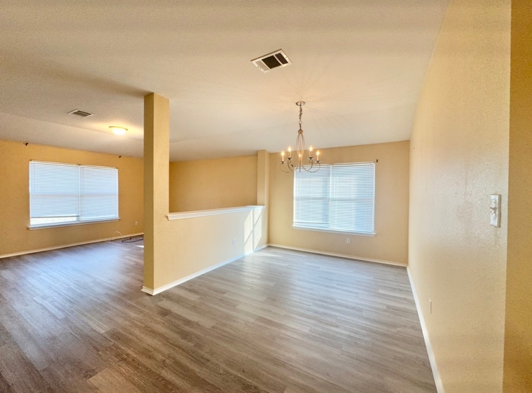 12809 Wood Lily Trail Elgin, TX 78621 - Photo 7 of 26 Unfurnished dining area with wood finished floors and a chandelier