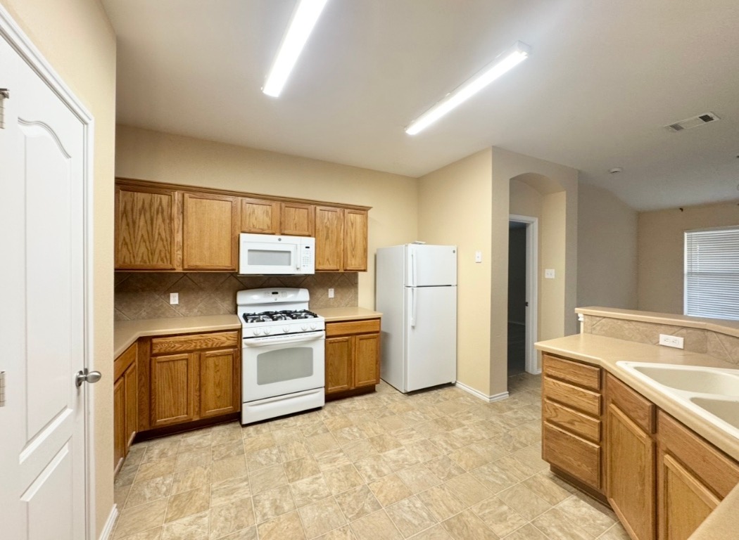 12809 Wood Lily Trail Elgin, TX 78621 - Photo 8 of 26 Kitchen featuring white appliances