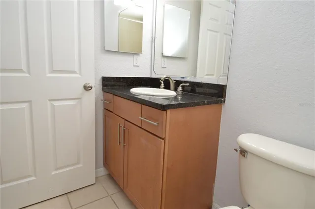 a view of an empty room with wooden floor and a ceiling fan