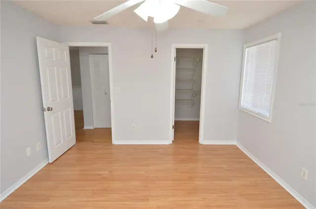 a view of a lake with a bench and trees in the background