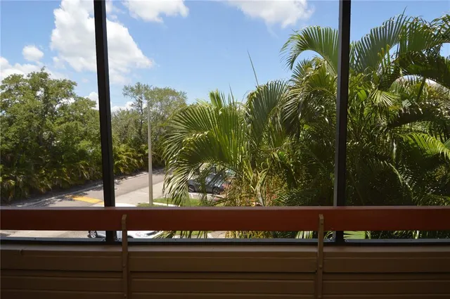 a view of swimming pool with seating space and trees in the background