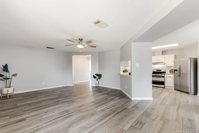 a view of an empty room with wooden floor