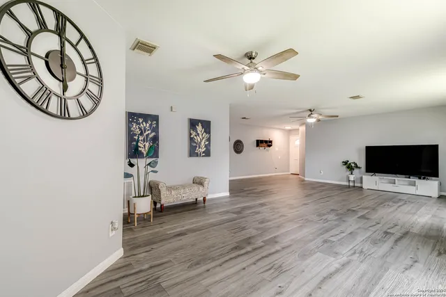 a view of an empty room with window and wooden floor