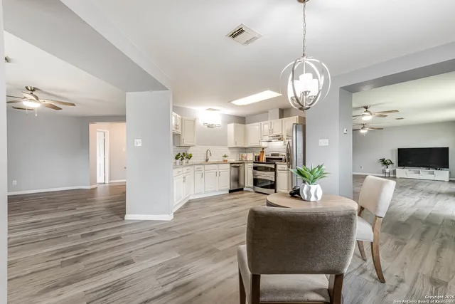 a view of a dining room and livingroom with furniture wooden floor a chandelier