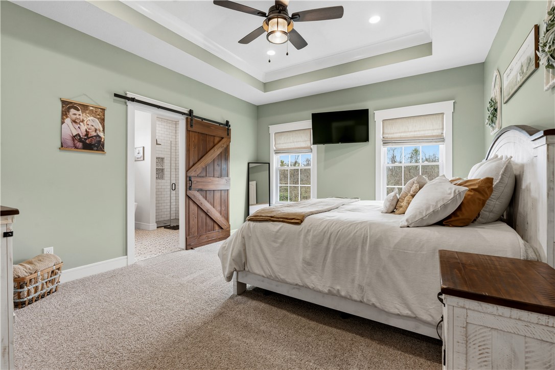 1158 Pyle Road Clarksville, OH 45113 - Photo 28 of 76 This primary bedroom offers a spacious retreat with a tray ceiling and warm, inviting finishes.