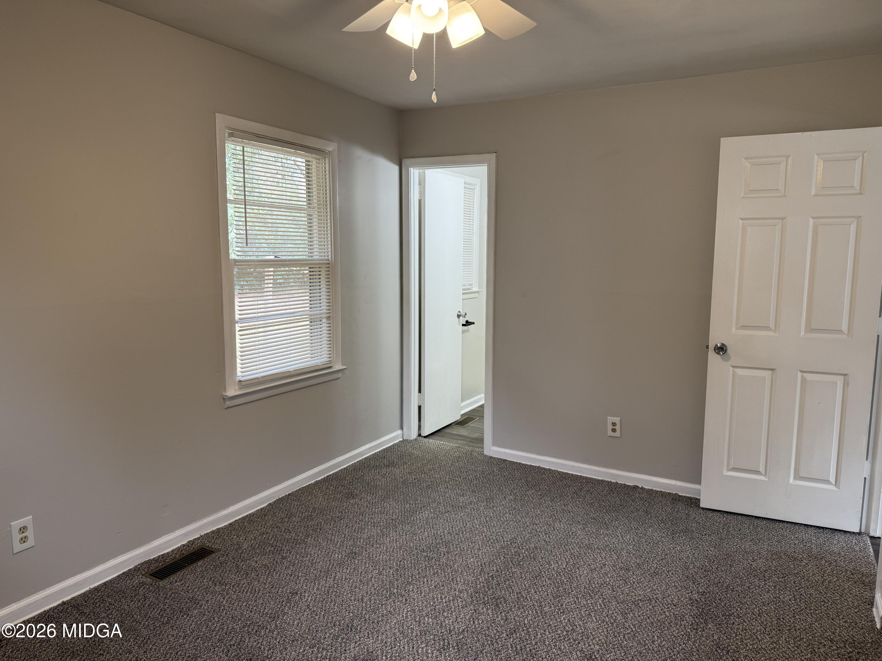 107 Miller Court Centerville, GA 31028 - Photo 11 of 16 an empty room with windows and chandelier fan
