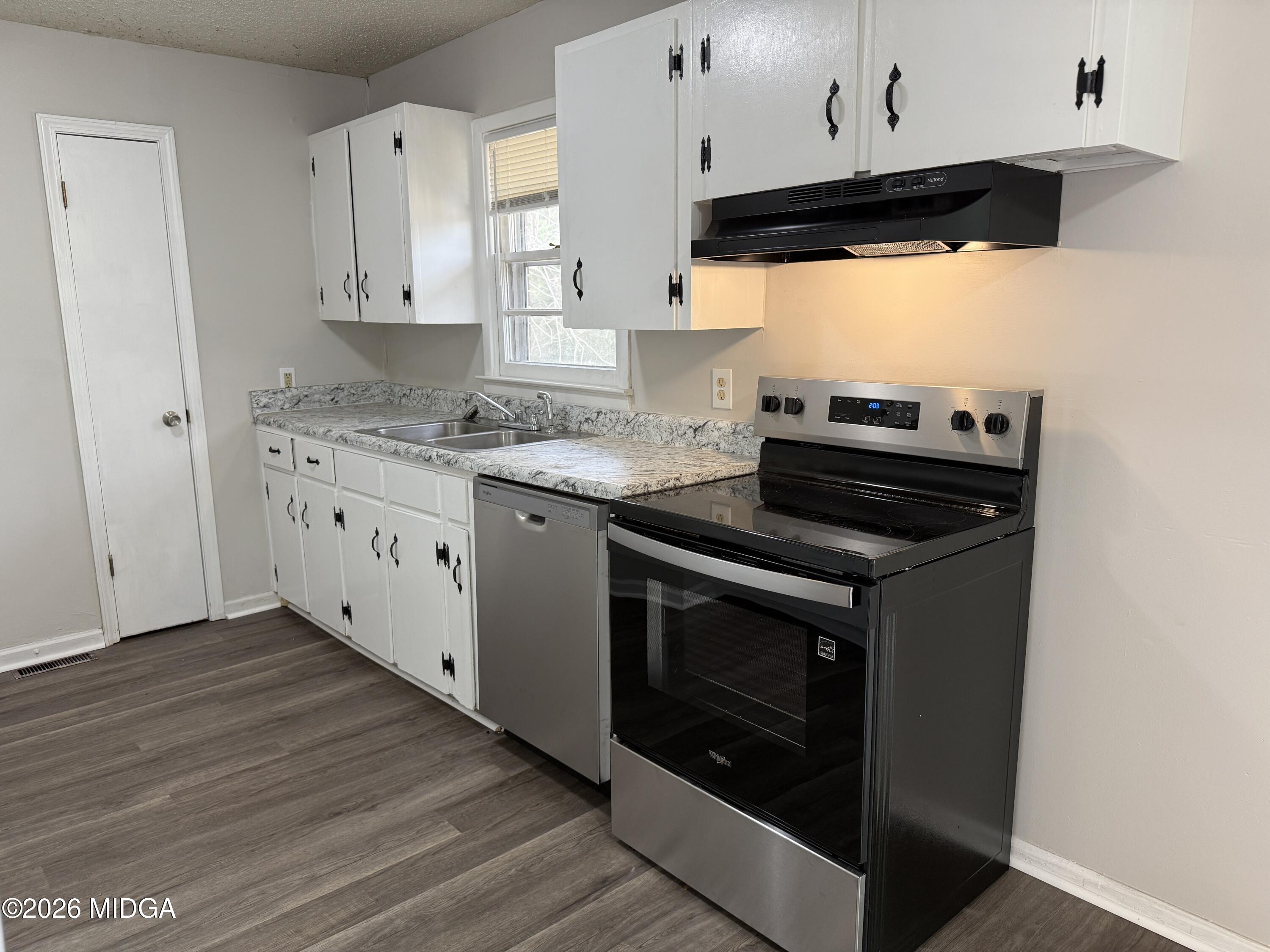 107 Miller Court Centerville, GA 31028 - Photo 5 of 16 a kitchen with stainless steel appliances a stove a sink and white cabinets