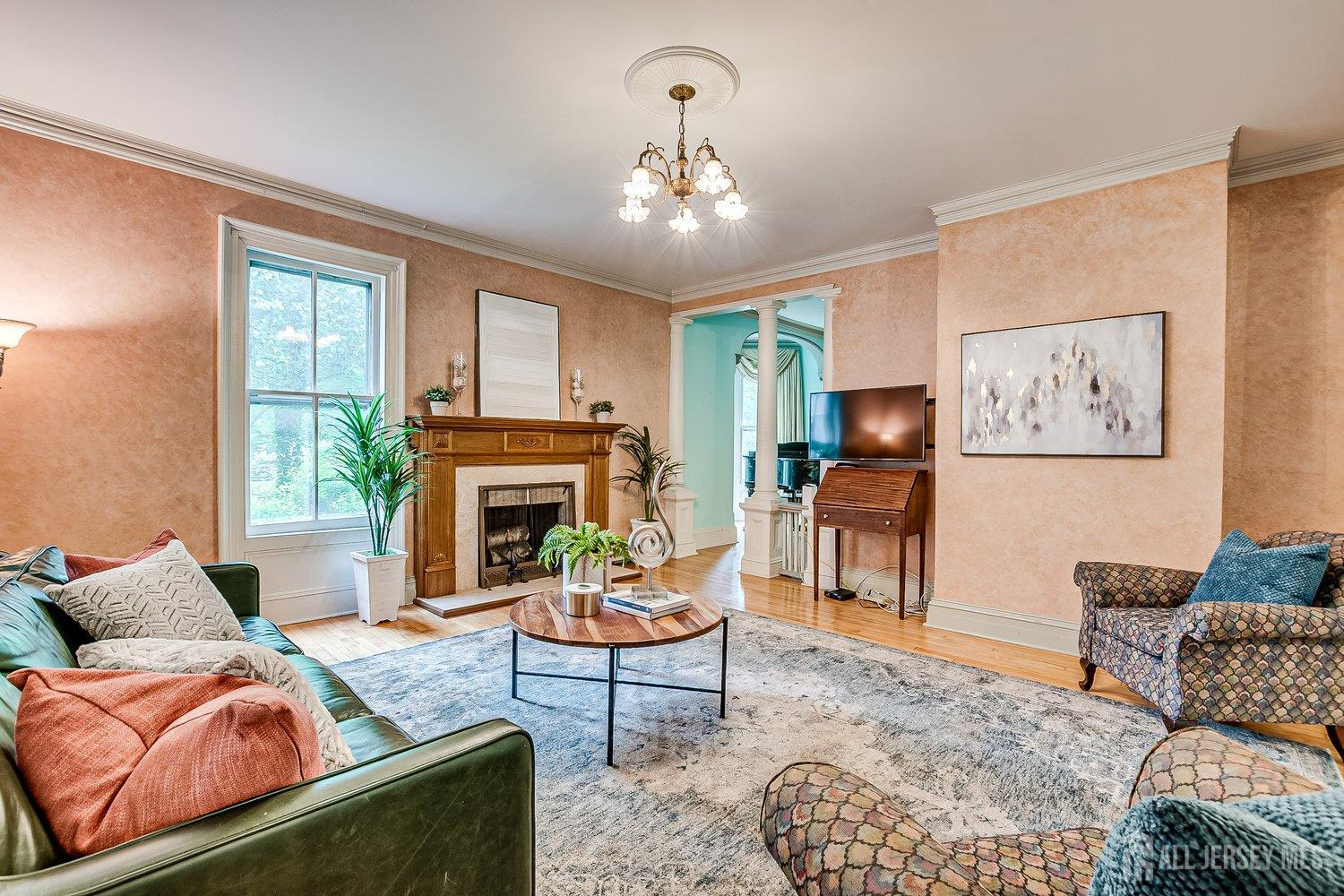 44 Rector Street Metuchen, NJ 08840 - Photo 34 of 65 a living room with furniture a chandelier and a fireplace
