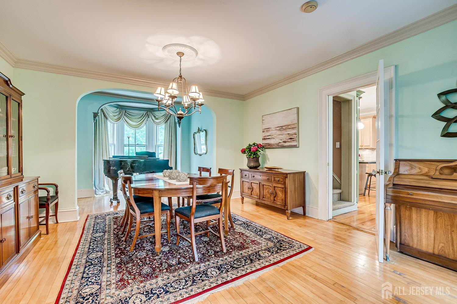 44 Rector Street Metuchen, NJ 08840 - Photo 36 of 65 a dining room with wooden floor a chandelier a wooden table and chairs