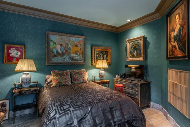 a bedroom with a bed and a lamp on dresser