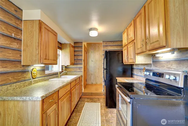 a kitchen with a stove a sink and a dining table view