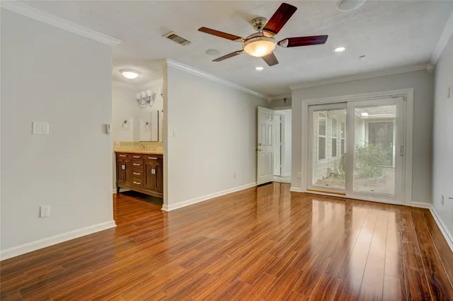 a view of an empty room and window wooden floor and a chandelier fan