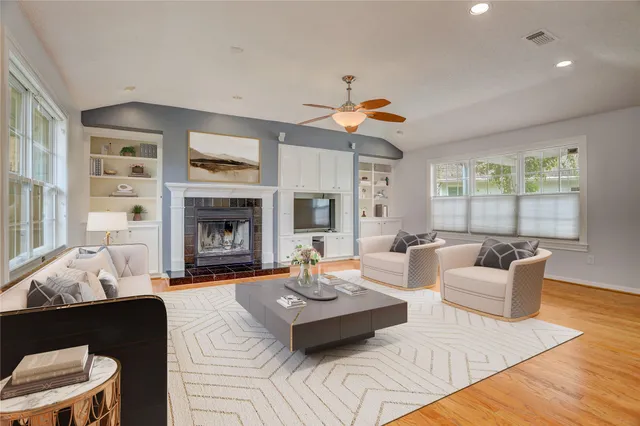 a living room with furniture fireplace and a large window