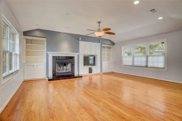 a view of an empty room with a window and fireplace