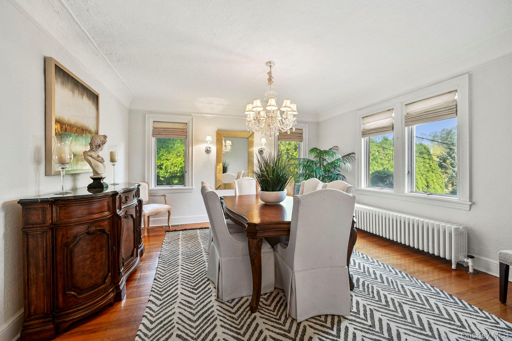 44 Fenimore Road New Rochelle, NY 10804 - Photo 8 of 46 a dining room with furniture a rug a potted plant and a chandelier