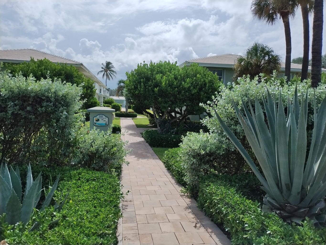 5500 Old Ocean Boulevard, Unit 210 Ocean Ridge, FL 33435 - Photo 25 of 27 a view of a garden with plants and large trees