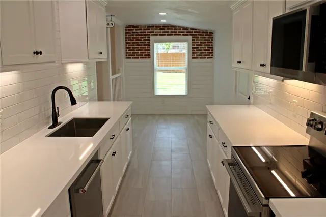 a kitchen with a sink a stove and cabinets