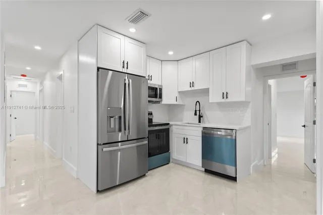 a kitchen with stainless steel appliances granite countertop a refrigerator and a sink