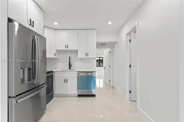 a kitchen with white cabinets and stainless steel appliances