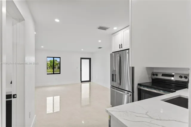 a kitchen with a refrigerator and a stove top oven