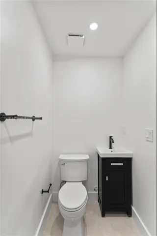 a bathroom with a toilet a sink and mirror