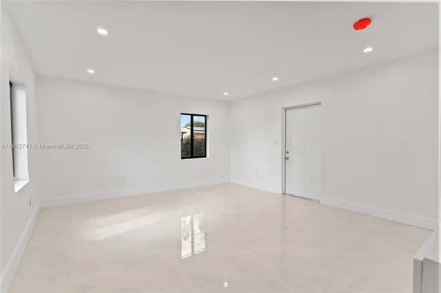a view of kitchen with white wooden cabinets and outdoor space