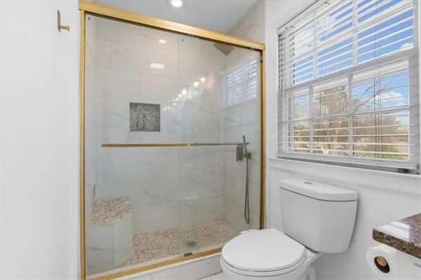 a bathroom with a toilet and a shower