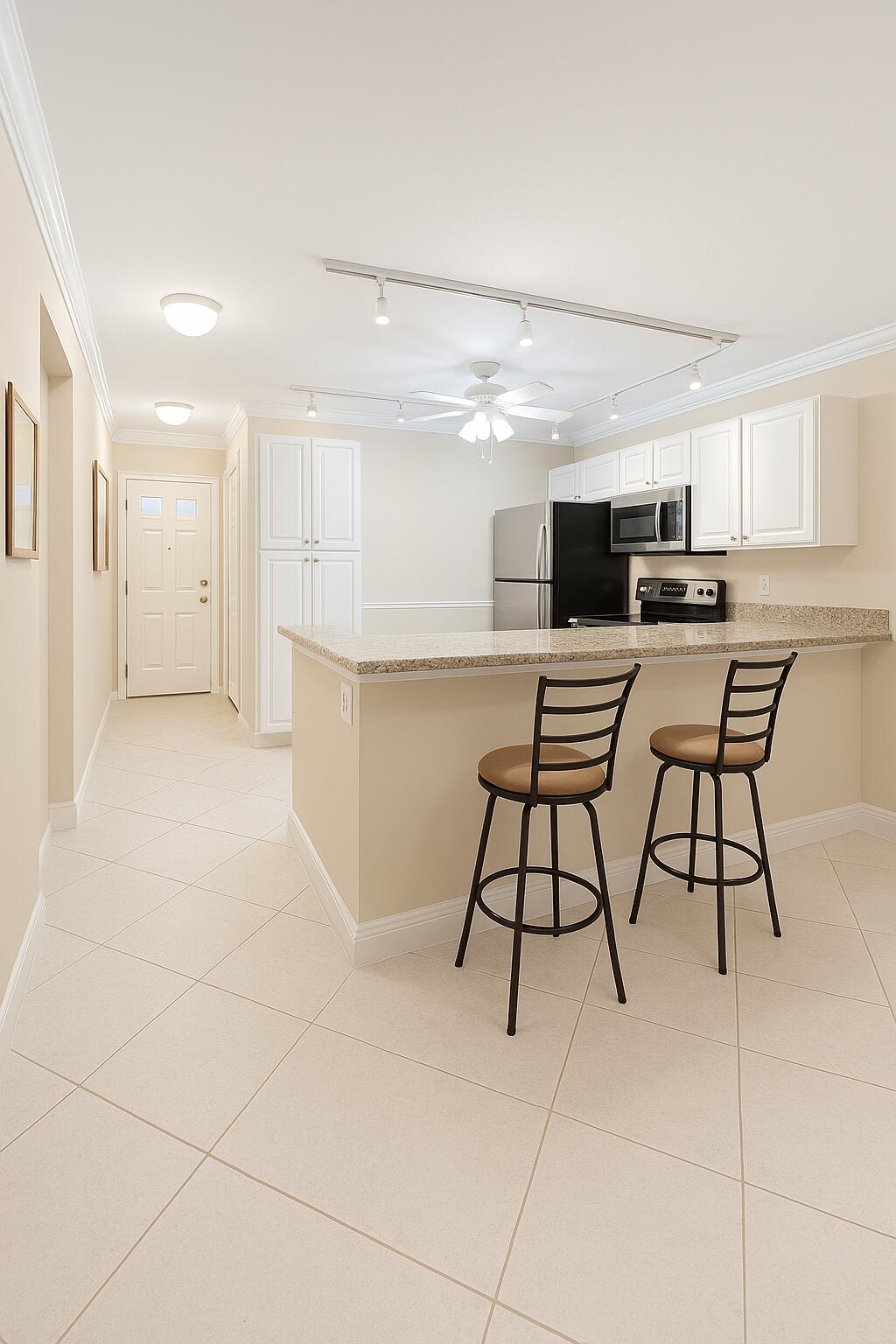 18900 Stewart Circle, Unit 7 Boca Raton, FL 33496 - Photo 2 of 23 a kitchen with a table chairs a sink and cabinets